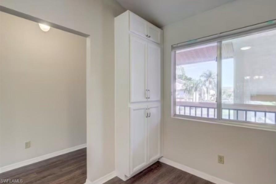 13130 White Marsh Lane, Unit 207 Fort Myers, FL 33912 - Photo 6 of 15 a view of an empty room with wooden floor and a window