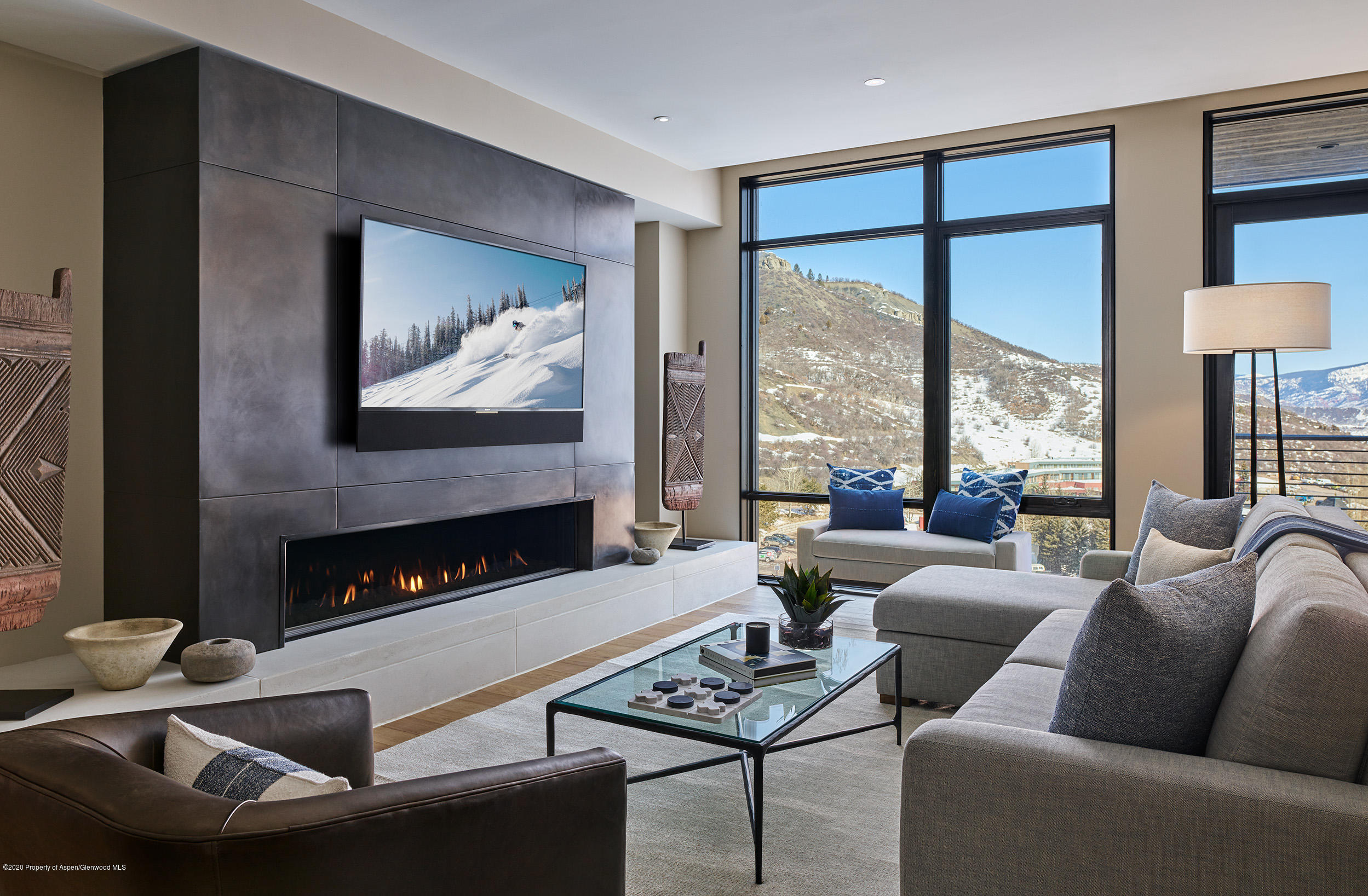 a living room with furniture a fireplace and a floor to ceiling window