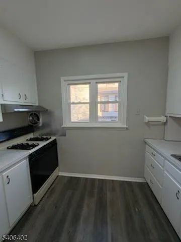 a kitchen with a stove and white cabinets