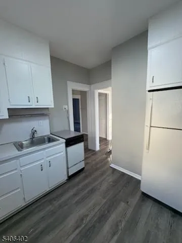 a kitchen with granite countertop white cabinets and white appliances