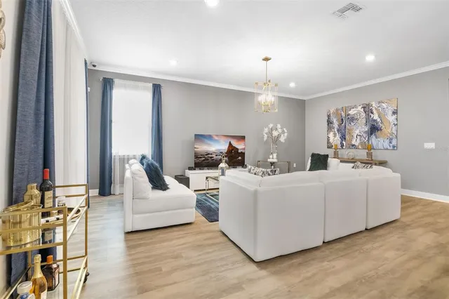 a living room with furniture and a chandelier
