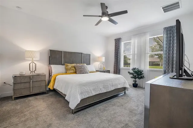 a bed room with a bed window and a flat screen television