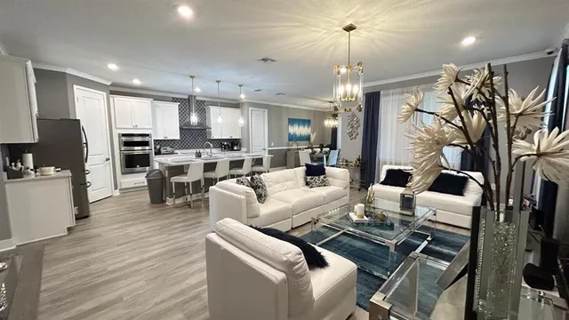 a living room with lots of furniture and kitchen view