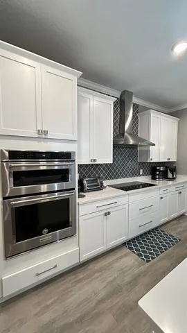 a kitchen with granite countertop white cabinets and appliances