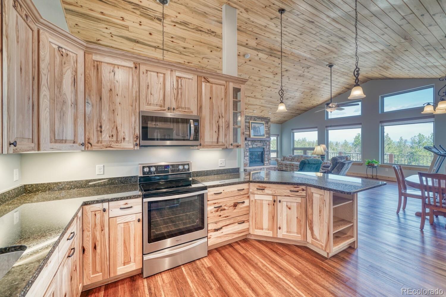 3561 Singletree Road Hartsel, CO 80449 - Photo 6 of 48 a kitchen with stainless steel appliances granite countertop a stove and a wooden floors