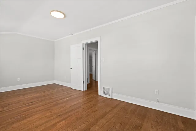 an empty room with wooden floor and white walls