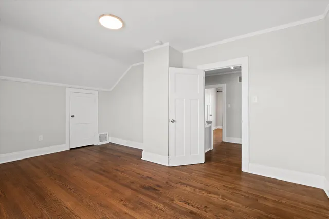 an empty room with wooden floor & windows