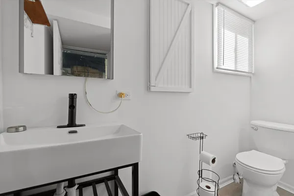 a bathroom with a sink a toilet and mirror