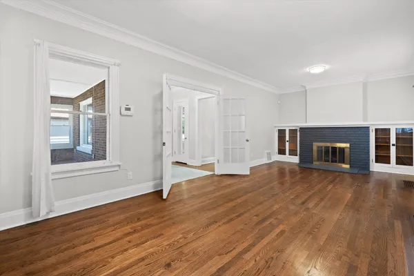 a view of empty room with wooden floor and fireplace