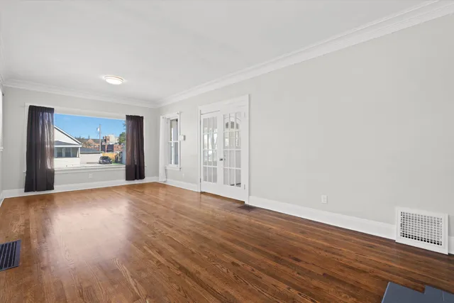 a view of empty room with wooden floor