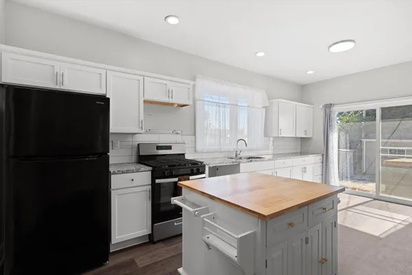a kitchen with a sink a stove a refrigerator and cabinets