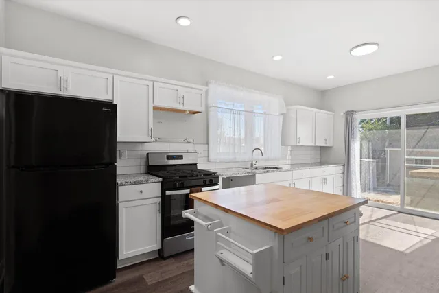 a kitchen with a sink a stove a refrigerator and cabinets