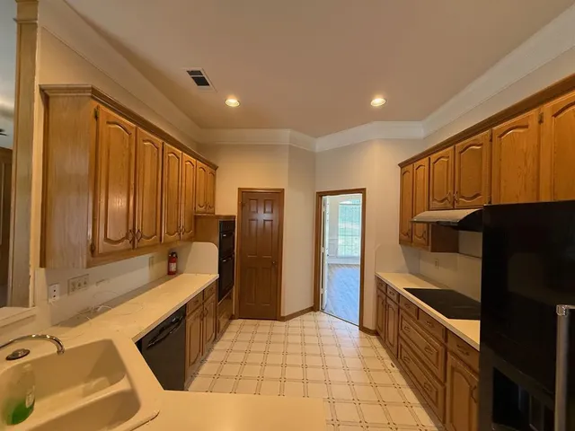 a kitchen with stainless steel appliances granite countertop a refrigerator and a stove top oven