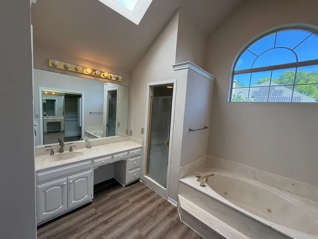 a bathroom with a tub a double vanity sink and mirror