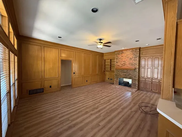 a view of an empty room with a fireplace and a window