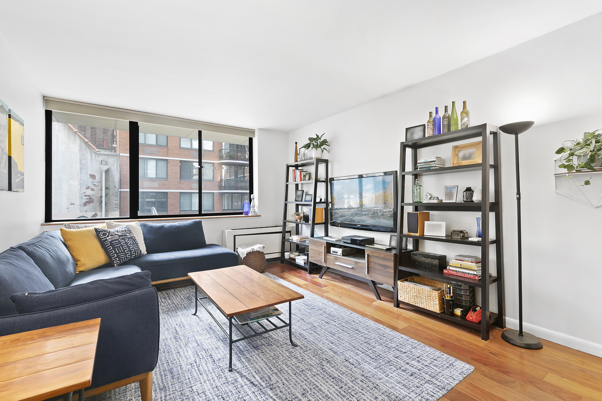 a living room with furniture a rug and a bookshelf