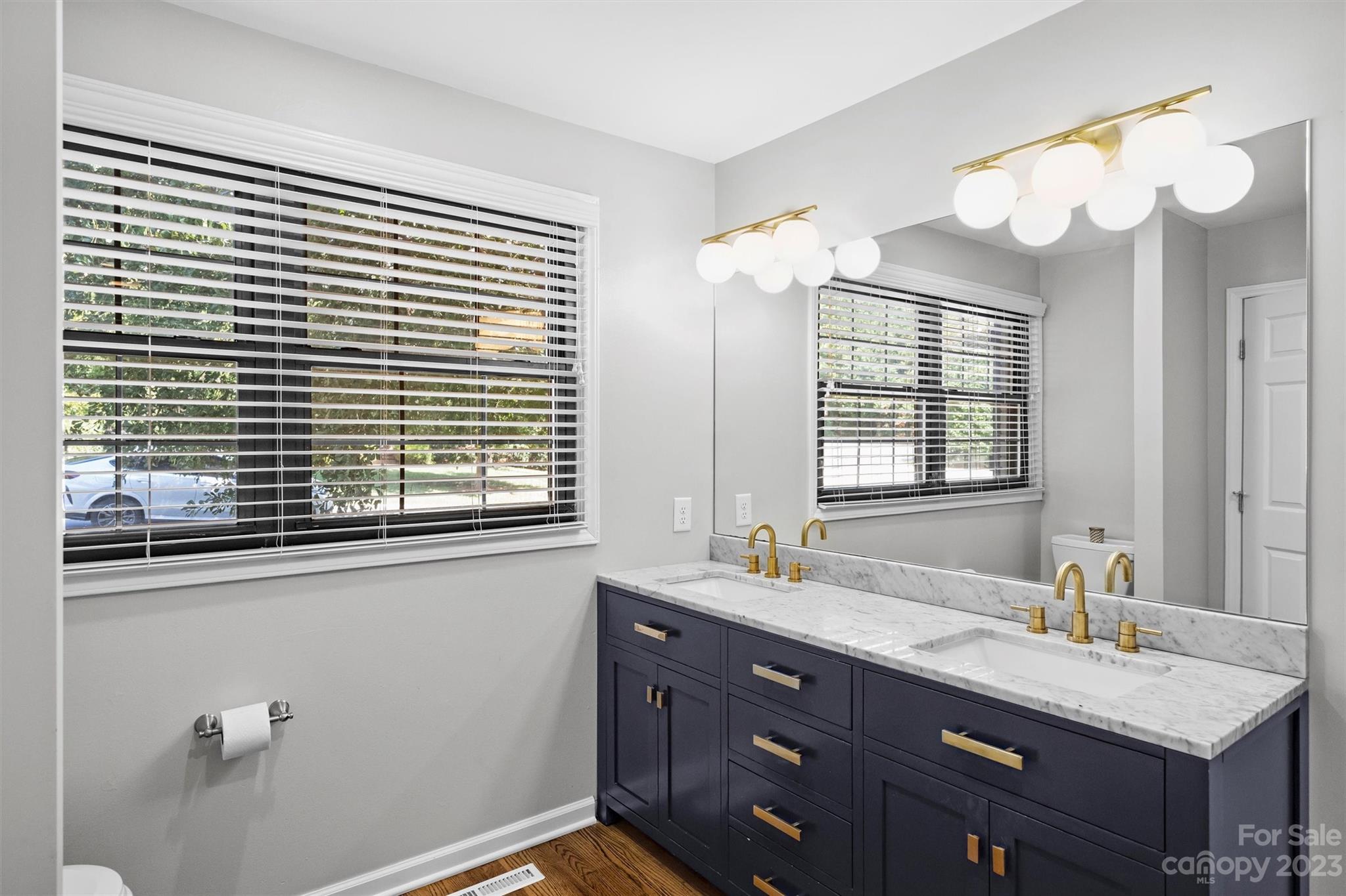 714 Brockbank Road Charlotte, NC 28209 - Photo 29 of 38 a bathroom with a granite countertop sink and a large mirror