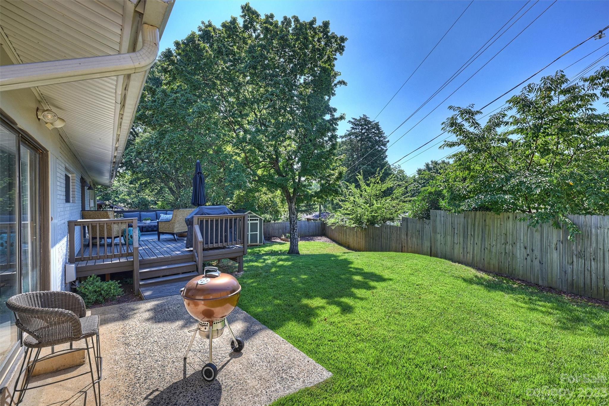 714 Brockbank Road Charlotte, NC 28209 - Photo 35 of 38 a view of a backyard with table and chairs potted plants and wooden fence