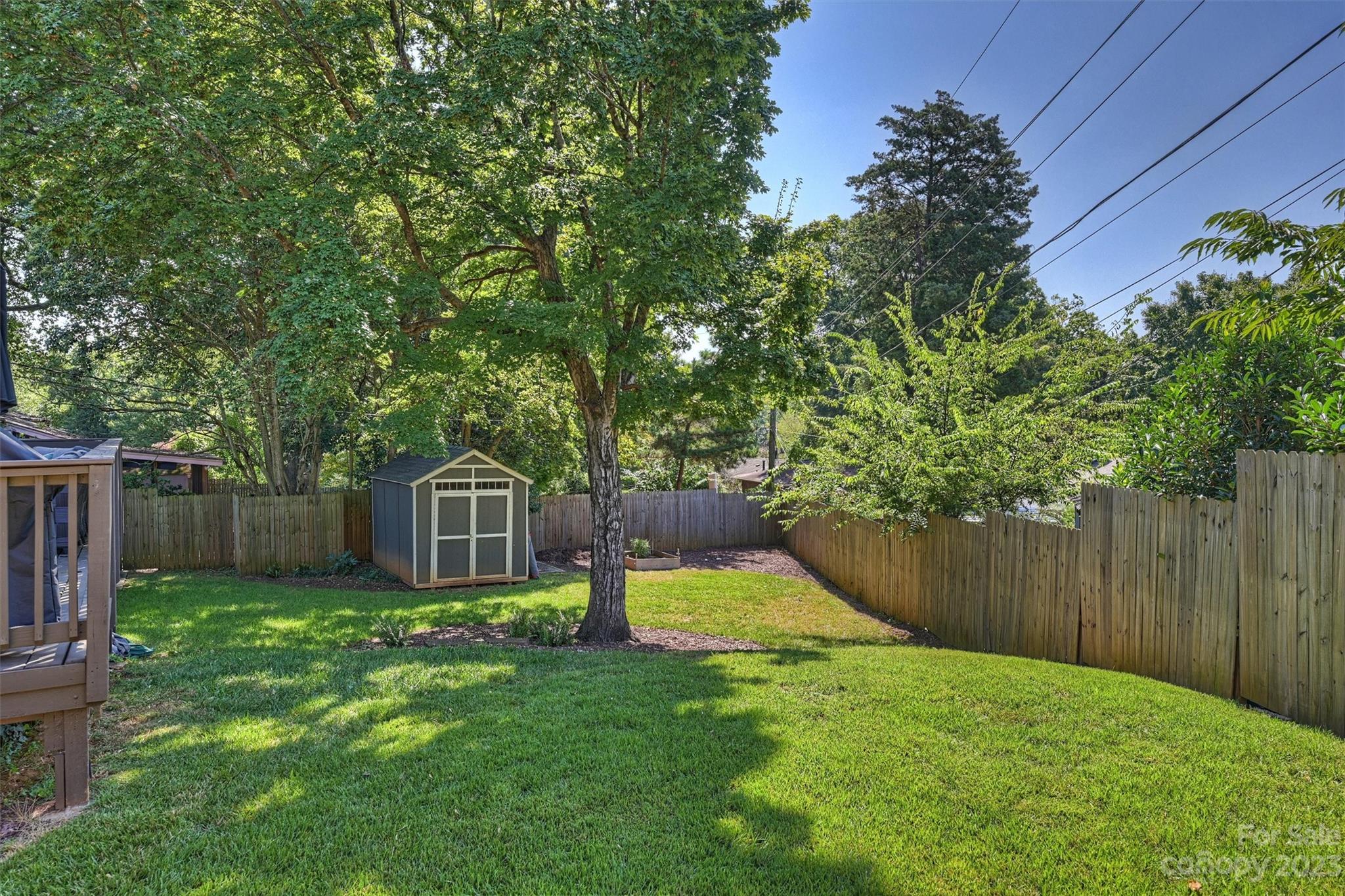 714 Brockbank Road Charlotte, NC 28209 - Photo 36 of 38 a view of a backyard with a small cabin and wooden fence