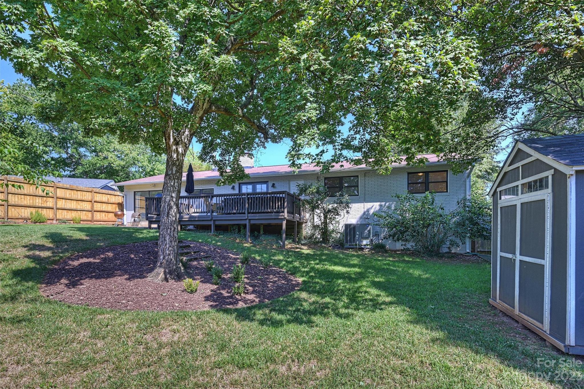 714 Brockbank Road Charlotte, NC 28209 - Photo 37 of 38 a view of a backyard with wooden fence and a large tree