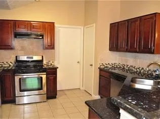 a kitchen with granite countertop a stove and a sink