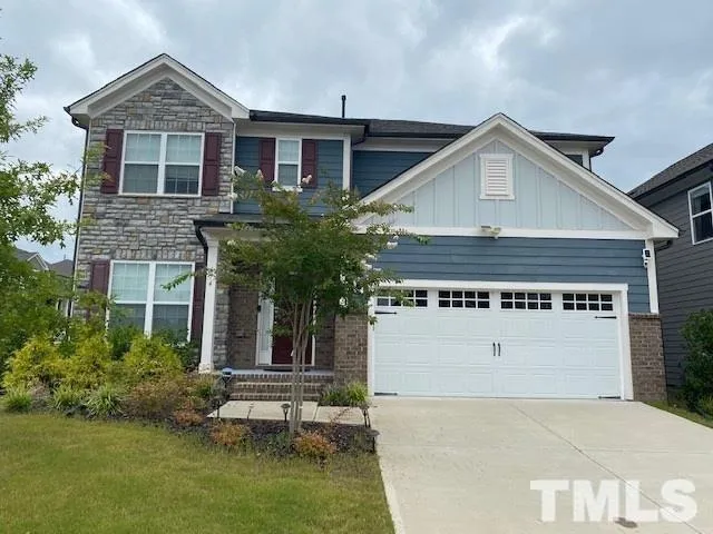 a view of a house with a yard and potted plants
