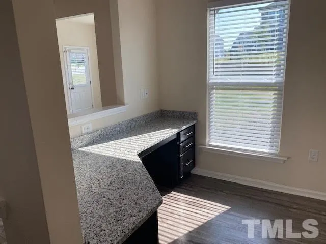 a kitchen with a granite countertop sink and cabinets