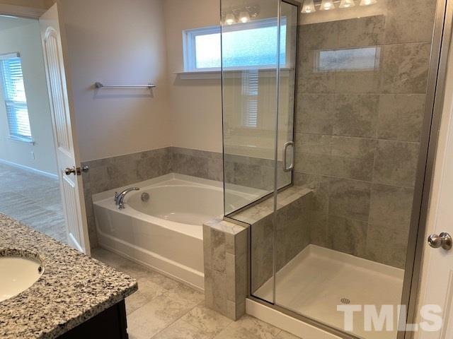674 Brook Pine Trail Apex, NC 27523 - Photo 15 of 30 a bathroom with a granite countertop bathtub and shower