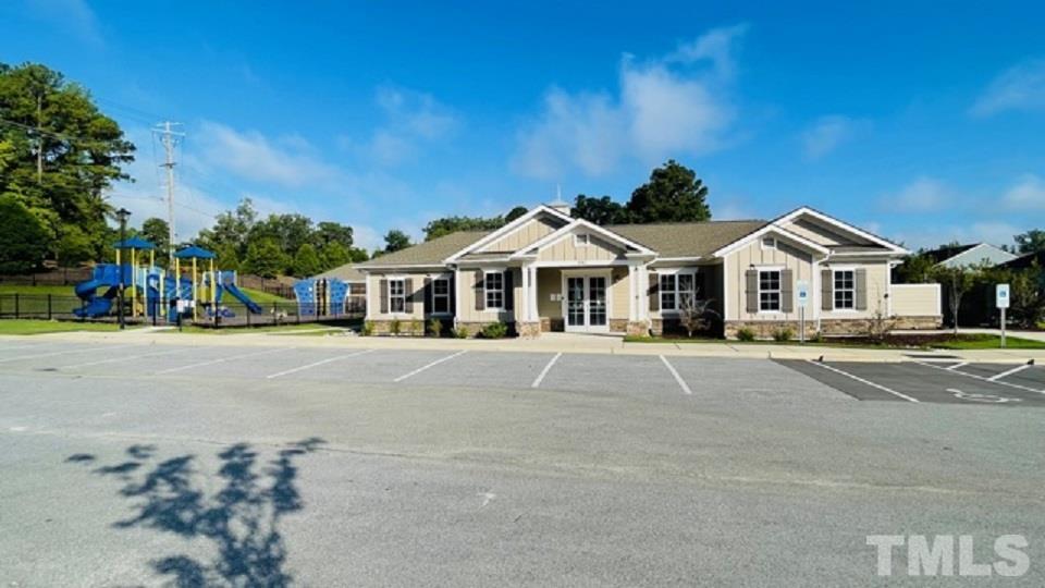 674 Brook Pine Trail Apex, NC 27523 - Photo 25 of 30 a view of white house with a yard and table and chairs under an umbrella