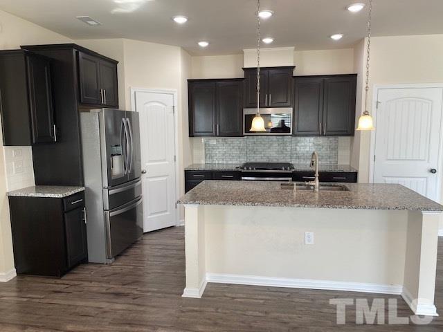 674 Brook Pine Trail Apex, NC 27523 - Photo 6 of 30 a kitchen with stainless steel appliances granite countertop a refrigerator a stove and a sink