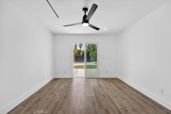 a view of room with window ceiling fan and hardwood floor