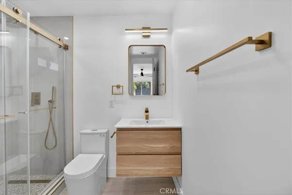 a bathroom with a sink vanity mirror and toilet