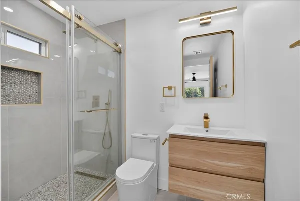 a bathroom with a sink a toilet and shower