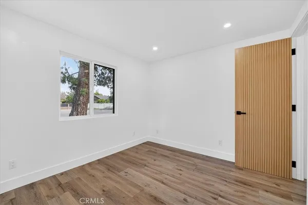 a view of a room with wooden floor and window