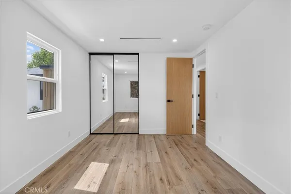 a view of empty room with wooden floor