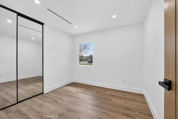 an empty room with wooden floor and door