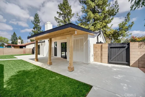 a view of a house with backyard and a tree