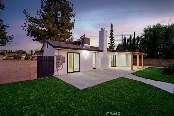 a view of a house with a yard and pathway
