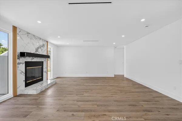 a view of empty room with wooden floor and fireplace