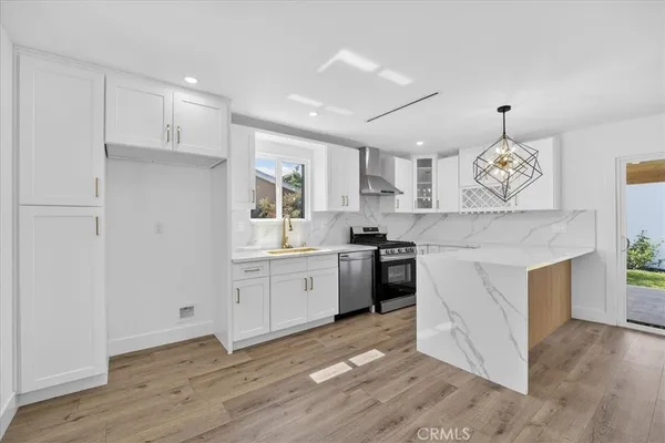 a large kitchen with cabinets wooden floor and stainless steel appliances