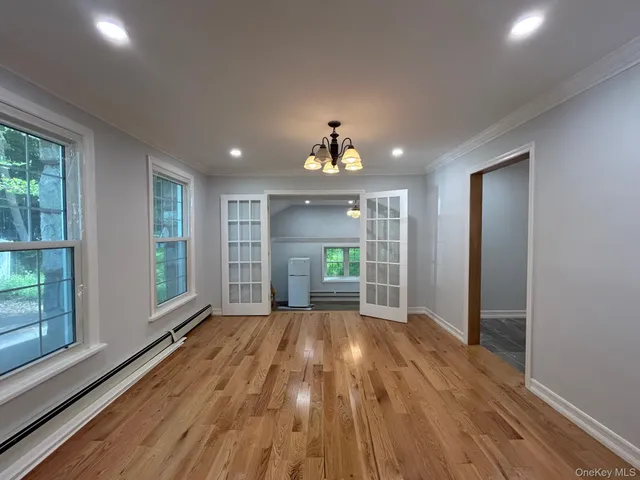 a view of a room with window wooden floor and front door