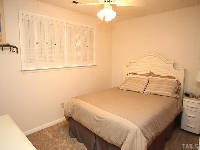 1108 Hardimont Road Raleigh, NC 27609 - Photo 17 of 25 a bedroom with a bed and a chandelier