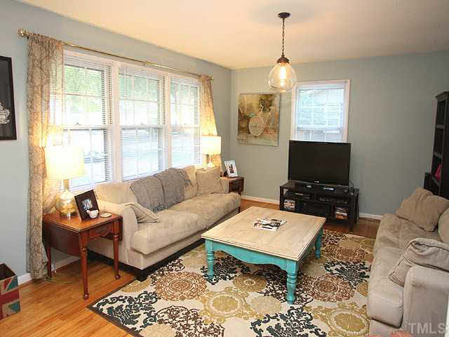 1108 Hardimont Road Raleigh, NC 27609 - Photo 4 of 25 a living room with furniture a flat screen tv and a large window