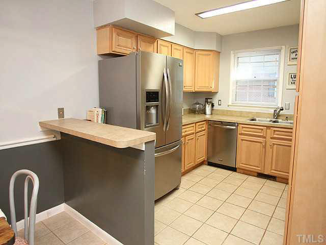 1108 Hardimont Road Raleigh, NC 27609 - Photo 9 of 25 a kitchen with a sink a refrigerator and cabinets