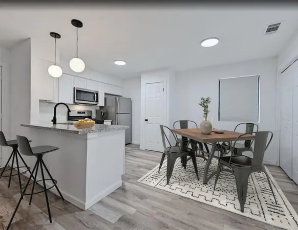 a kitchen with a table chairs and a refrigerator