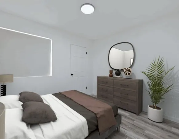 a bedroom with a bed and a potted plant