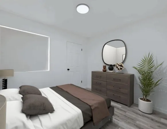 a bedroom with a bed and a potted plant