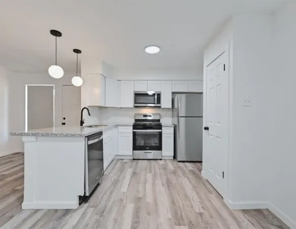 a kitchen with granite countertop a stove top oven and cabinets