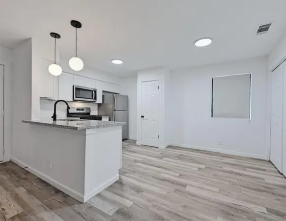 a kitchen with a refrigerator and a stove top oven