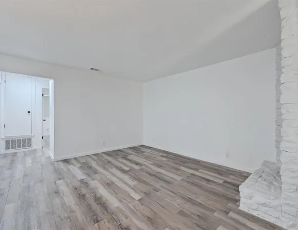 a view of an empty room and kitchen view